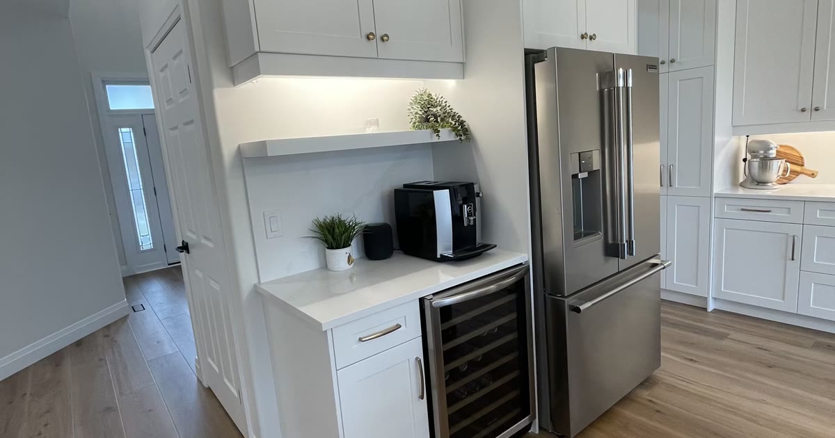 White kitchen cabinetry with stainless appliances — a HandKind Construction renovation